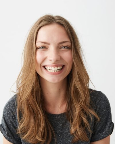 Young cheerful happy girl smiling laughing looking at camera over white background. Copy space.